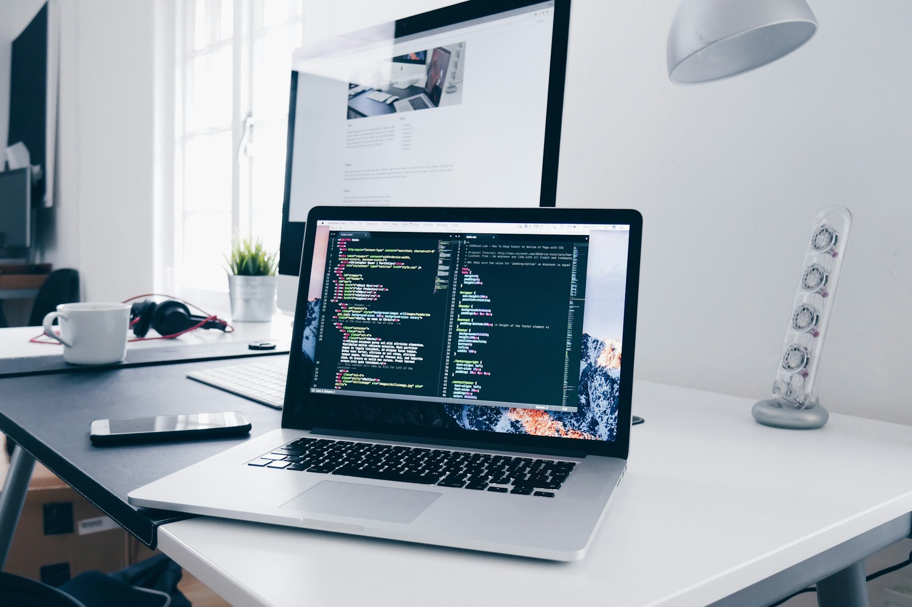 A daylight desk with code on the laptop